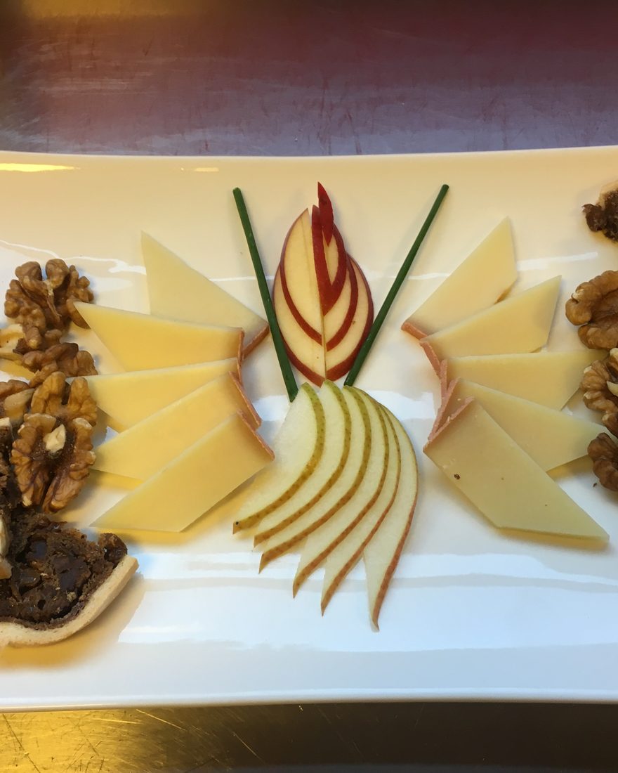 Käseteller mit Birnenbrot, Baumnüssen und aufgefächertem Apfel